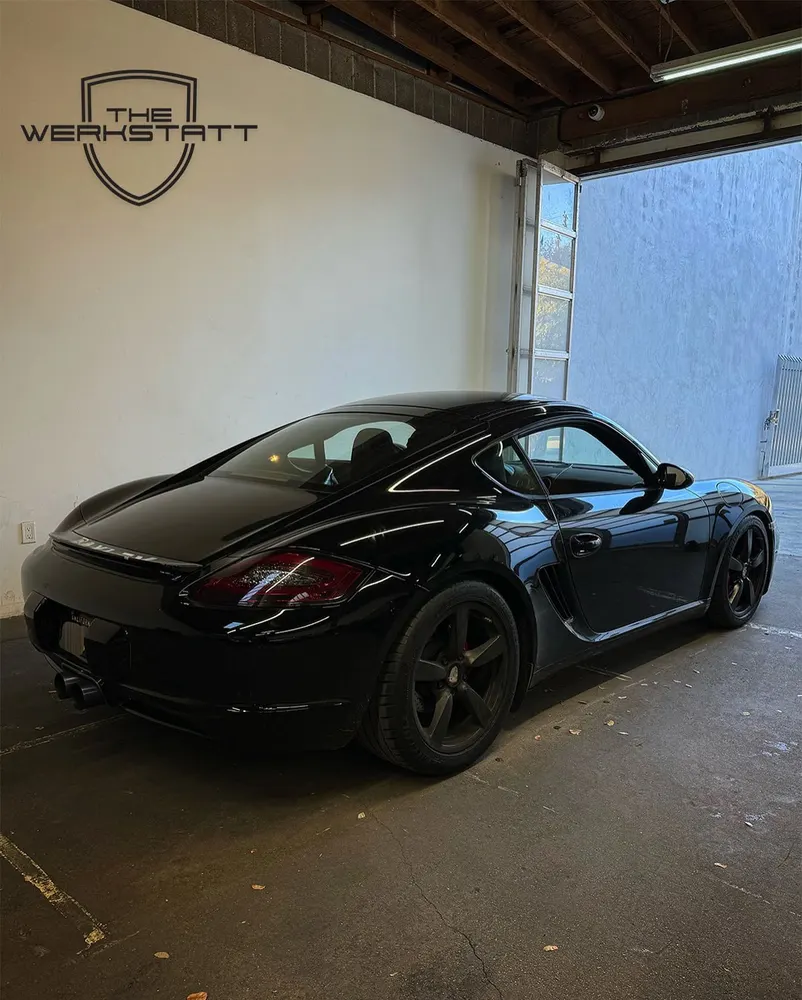 Black Porsche Cayman inside The Werkstatt
