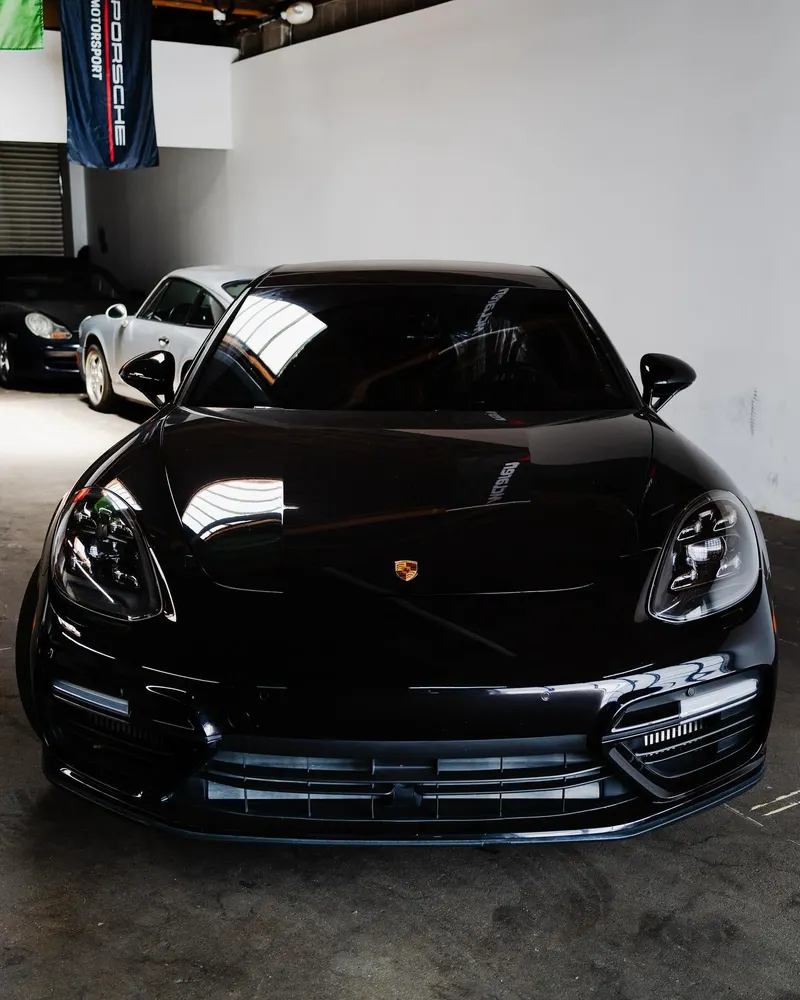 Front of a black Porsche Panamera in the shop