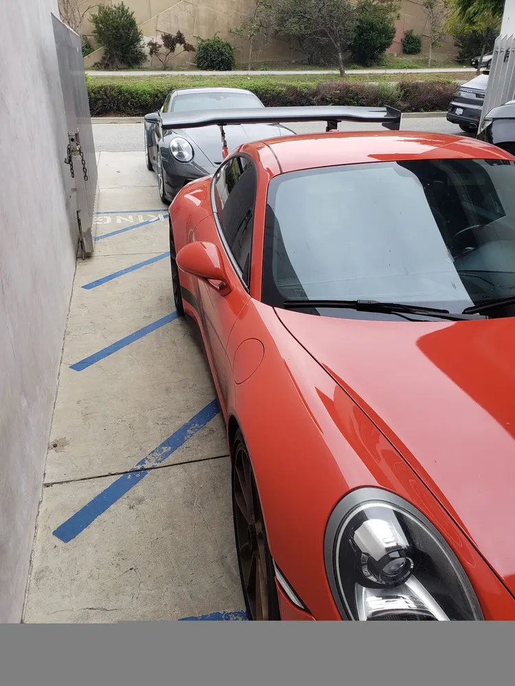 Orange Porsche 911 parked outside the shop