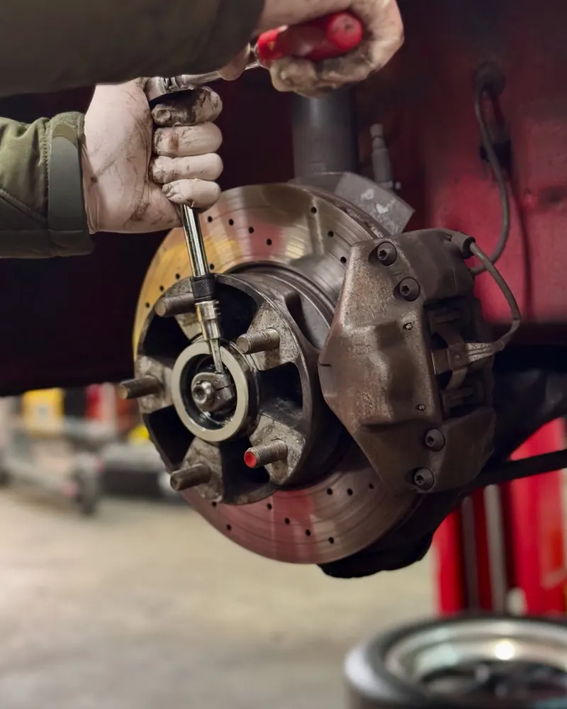 Technician working on a Porsche brake rotor and hub