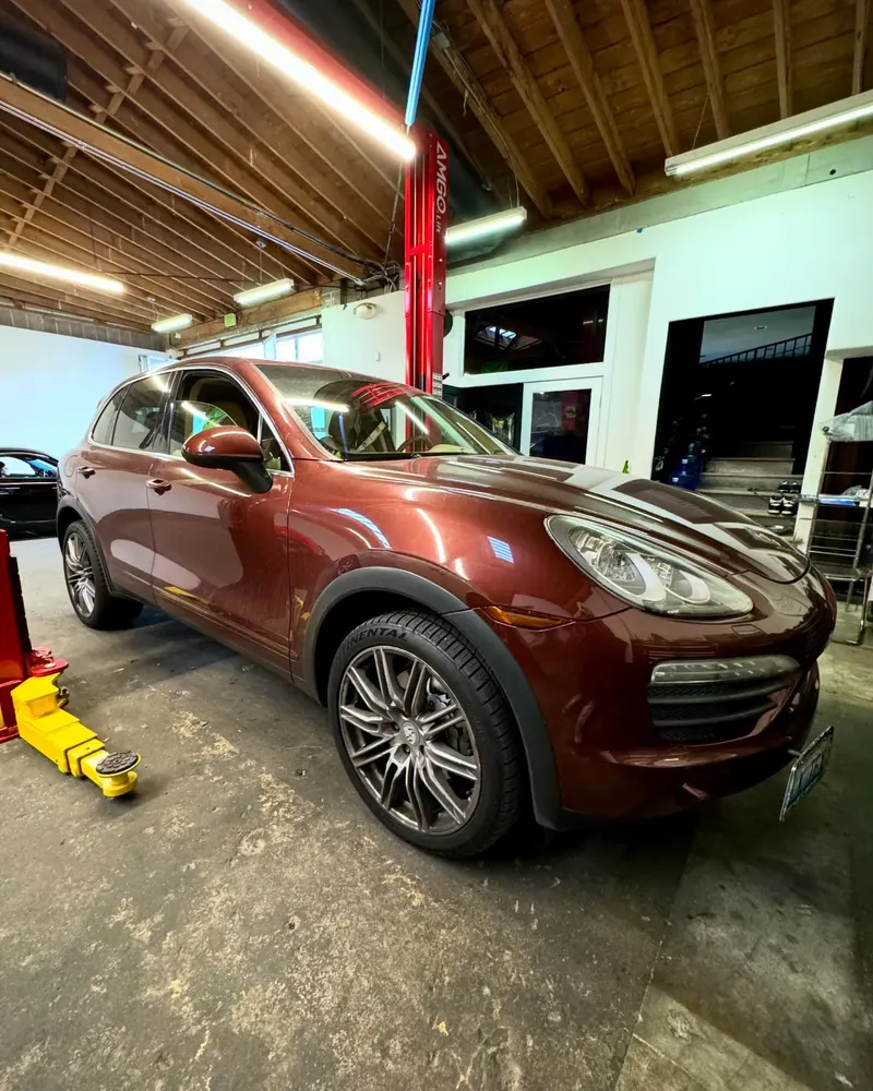 Porsche Cayenne positioned on a two-post lift